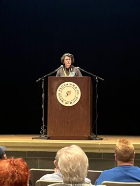 Cville Dem Erin Monaghan, who worked as Legislative and Policy Director for the Virginia House Democratic Caucus, reads out the rules for the Virginia Fifth District Democratic Convention, May 18, 2024, from behind a podium.