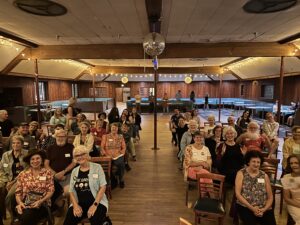 Photo of several dozen Dems in the Frys Spring Beach Club dance hall awaiting the start of the Harris-Trump debate 9-10-2024.