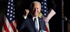 Photo of Pres. Joe Biden, wearing a blue suit and flue tie, with his right hand in a fist.