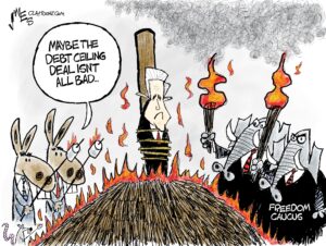 1-panel cartoon showing Speaker Kevin McCarthy tied to a stake in the middle of a bonfire. Two Republican elephants labeled "Freedom Caucus" stand to the right holding flaming torches. Two Democratic donkeys to the left are holding skewers with marshmallows over the flames, and one says "Maybe the debt ceiling deal isn't all bad.".