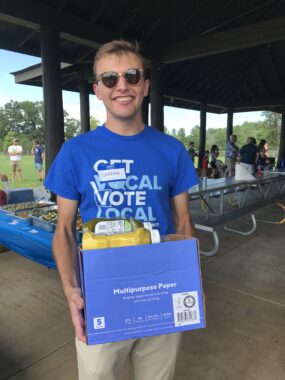 Photo of Carrson Everett wearing sunglasses and a blue "Get Vocal Vote Local" T-shirt at the Albemarle+Cville Dems Picnic 20230730