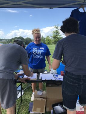 Photo of Karen Combs wearing a blue "Get Vocal Vote Local" T-shirt at the Albemarle+Cville Dems Picnic 20230730