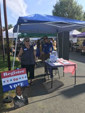 photo showing 2 Cville Dems women volunteering at our voter registration booth at Ix market on september 9, 2023