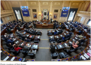 Overhead photo of the Virginia Legislature in session with lawmakers sitting inside the chamber at their desks