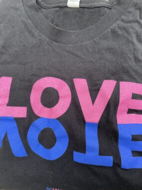 Tshirt that has the word "Love" in pink capital letters on top of the word "Vote" in upside down blue capital letters (creating a mirror image effect).