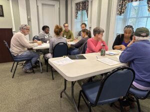 Cville Dems discuss issues at long tables at a meeting.